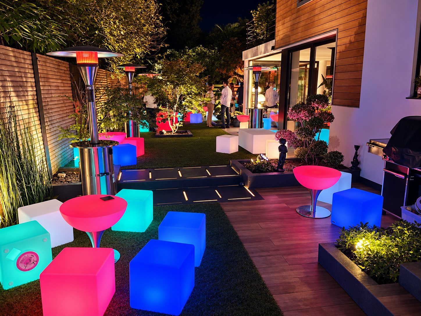 Mobilier lumineux multicolore et éclairages dans un jardin de réception