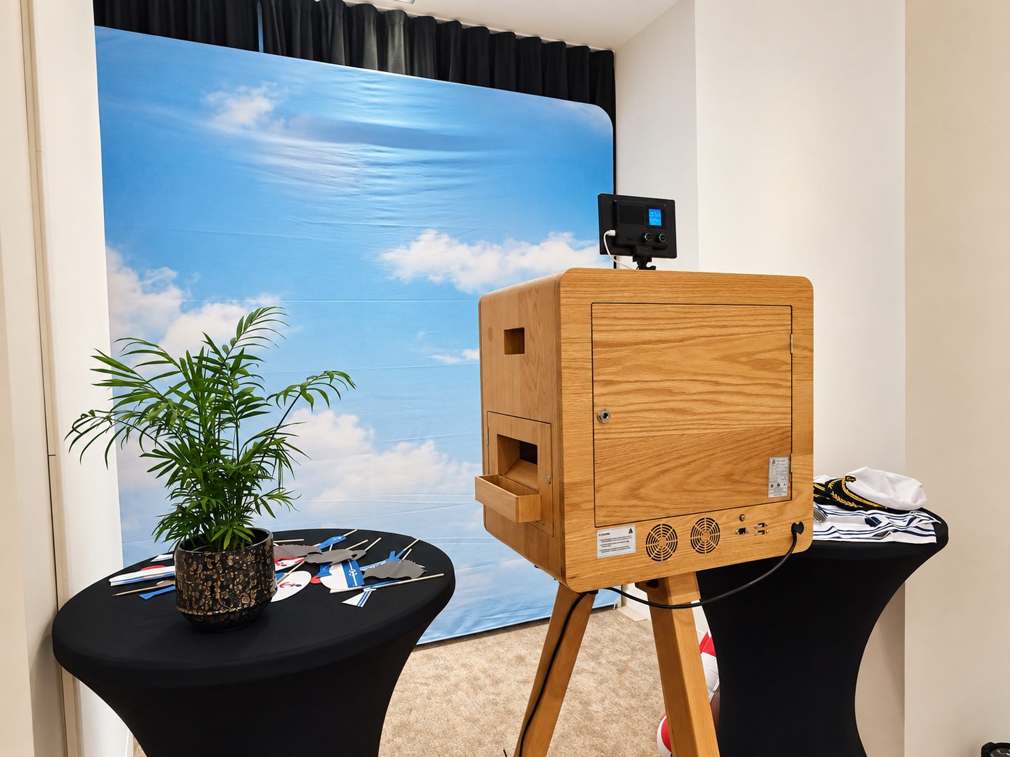 Installation d’un photobooth avec un fond marin et une table d’accessoires