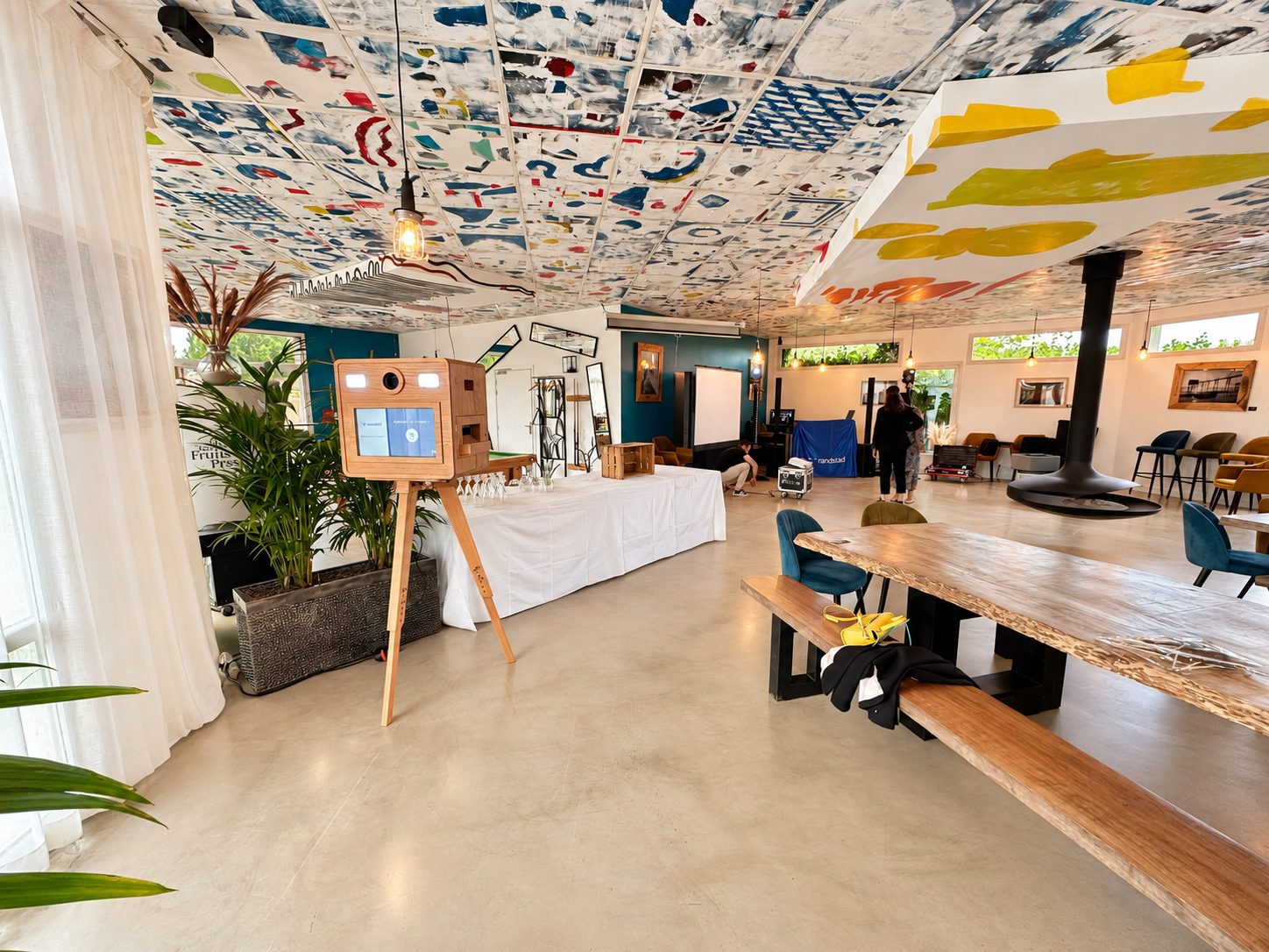 Photobooth dans un espace de réception avec de grandes tables en bois