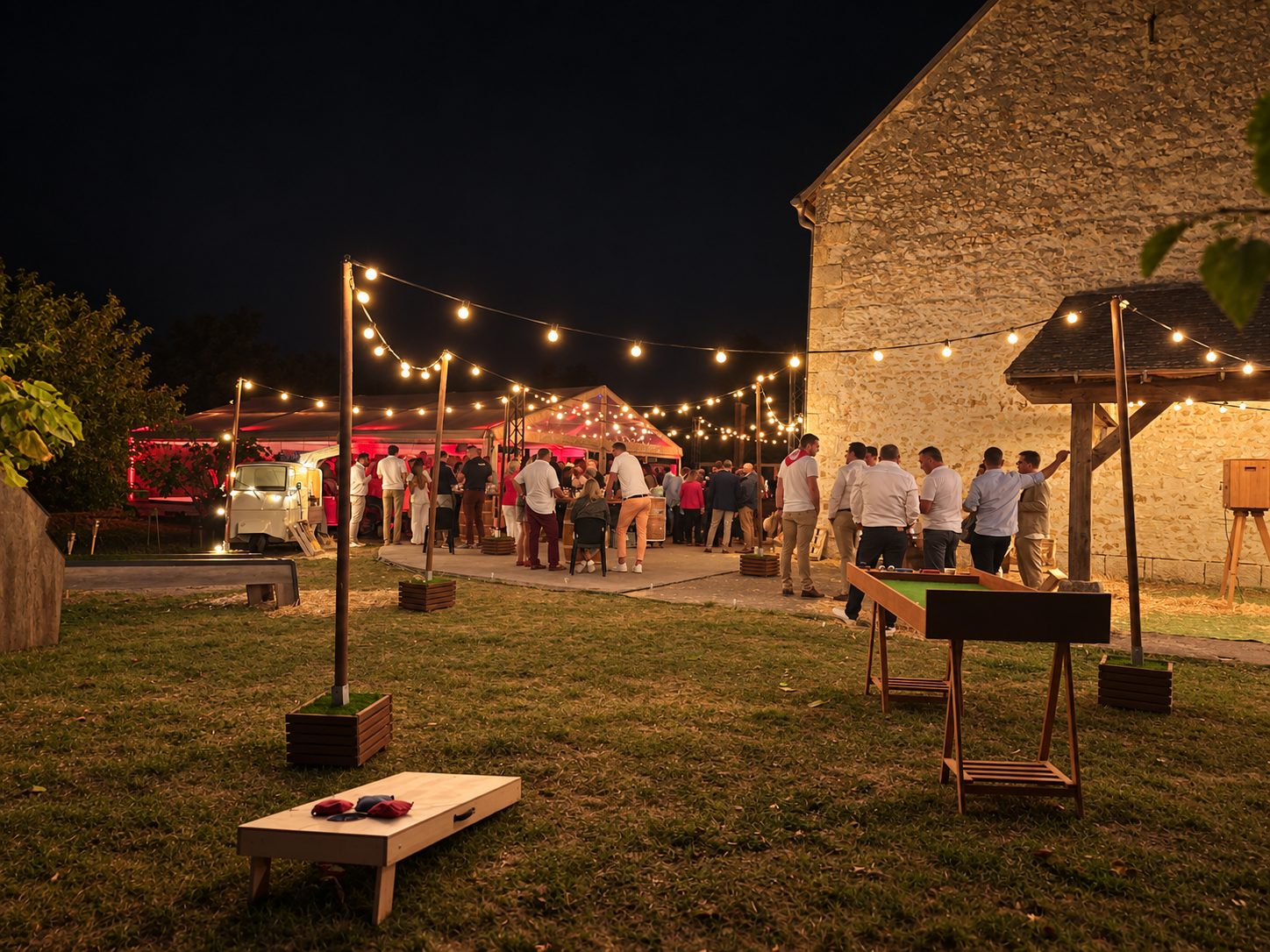 Cocktail en extérieur sous les guirlandes, devant un bâtiment en pierre