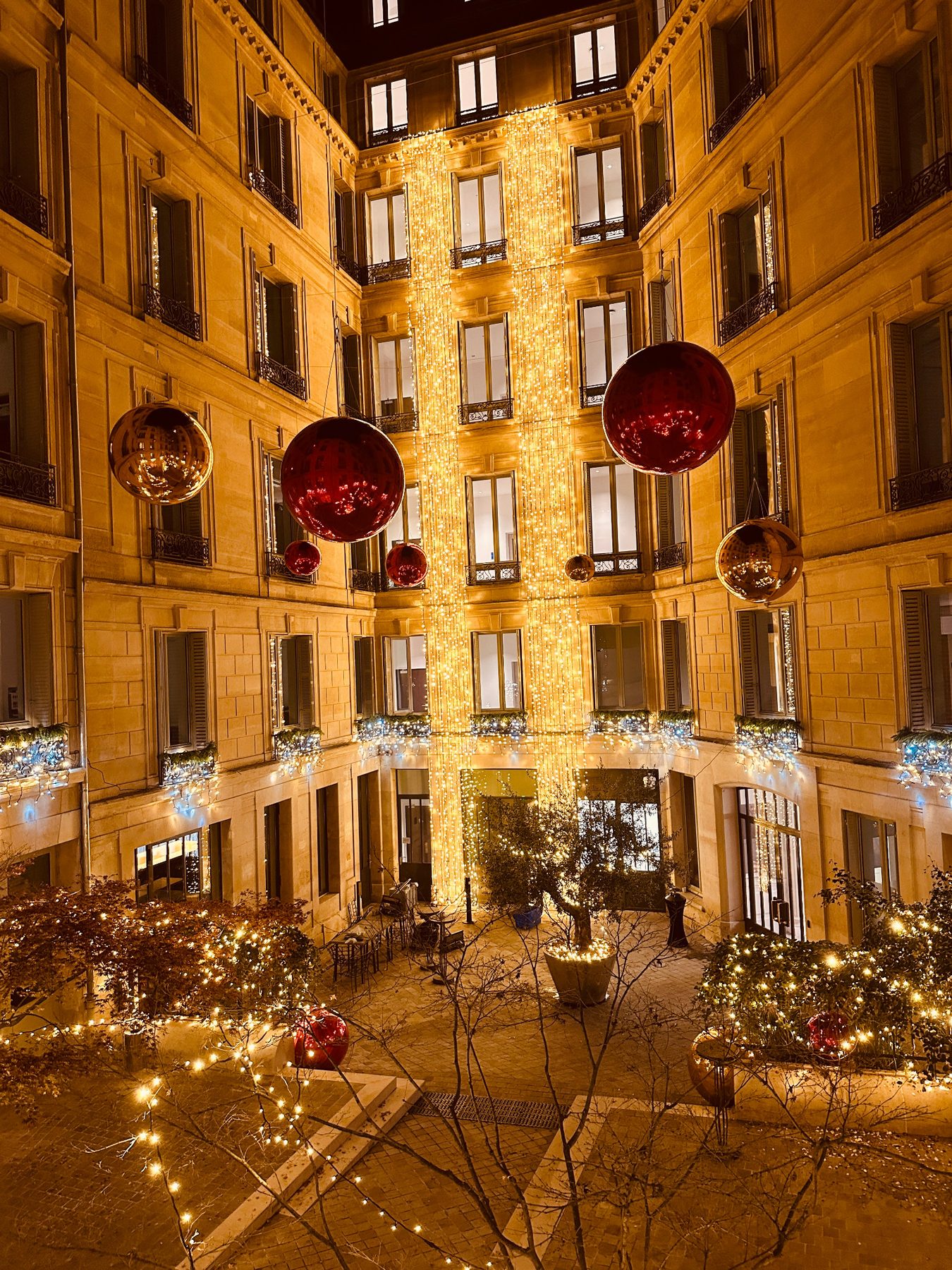 Cour intérieure décorée de guirlandes dorées et de sphères rouges pour Noël